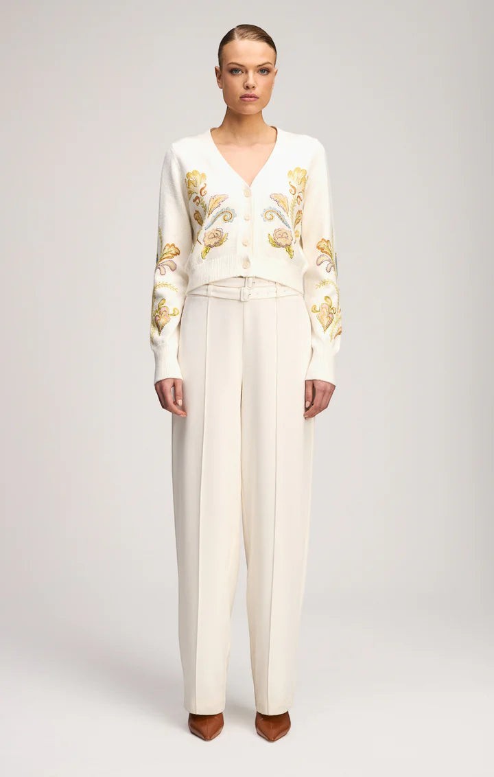 Coats and co. cream V-neck cardigan with floral embroidery, button-down front, and ribbed trim worn with cream trousers.