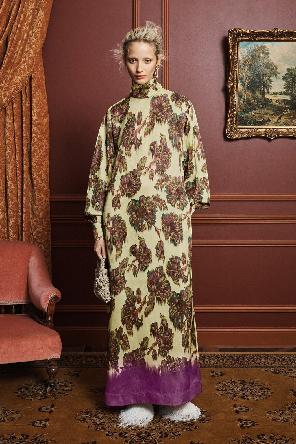 Model wearing a Coats and co. yellow and purple floral print maxi dress with long sleeves in a vintage-style room.